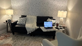 Consultation room at the SeaChange Mental Health office in Navarre, with a sofa, throw blankets and soft lamplight